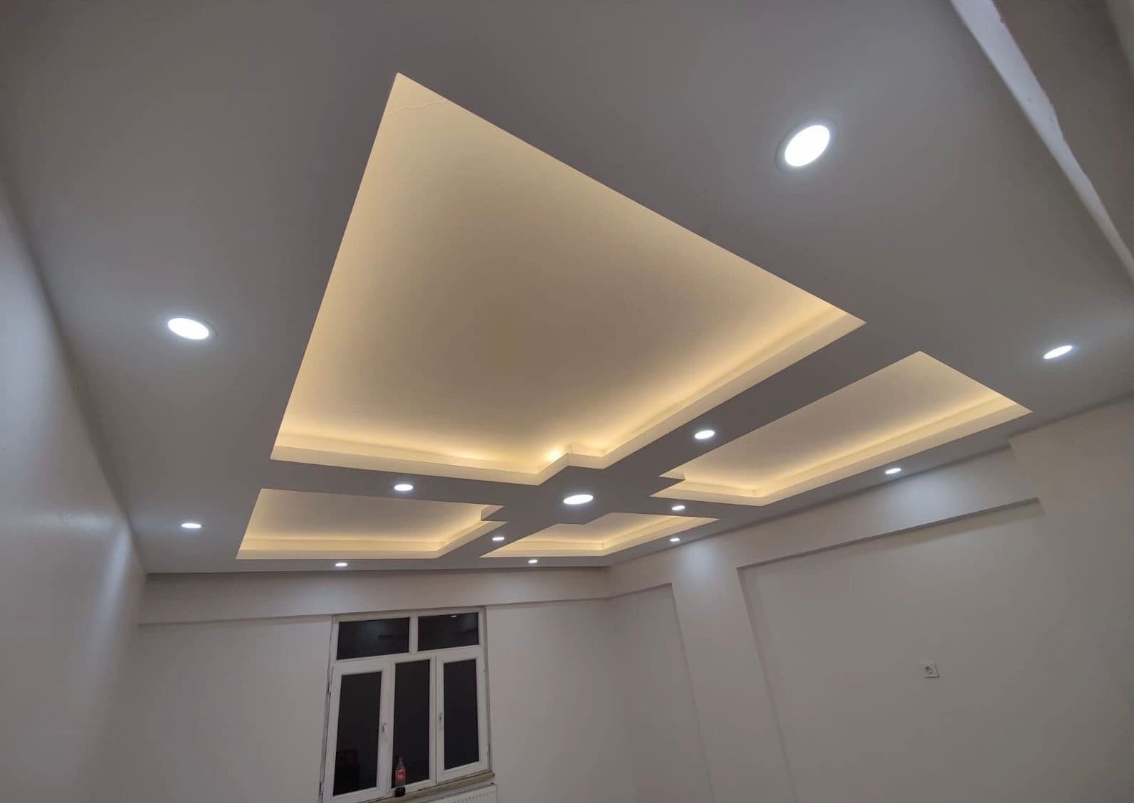 Bitmiş kademeli alçıpan tavan; gizli LED aydınlatmalı, spot aydınlatmalar, pencere görünür.